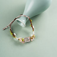 Daisy Chain — bracelet styled beside a pale green ceramic vase
